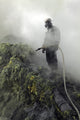 Miner waiting for water to cool piping on sulphur mine at Kawah Ijen volcano, Java, Indonesia poster print.