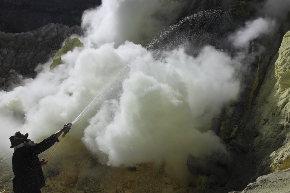 Miner cooling condensation pipes at Kawah Ijen volcano in Java, Indonesia poster print.