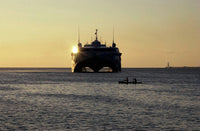 Fishermen canoeing past the US Navy contracted High Speed Vessel Two HSV-2 SWIFT poster print.