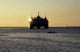 Fishermen canoeing past the US Navy contracted High Speed Vessel Two HSV-2 SWIFT poster print.
