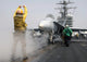 Aviation Boatswain's Mate directs an F/A-18C Hornet onto a steam-powered catapult - Poster Print