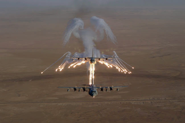 Aerial shot of a KC-130 Stratotanker firing flares over Iraq.