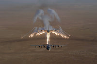 Aerial shot of a KC-130 Stratotanker firing flares over Iraq.
