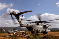 Soldiers and sailors unloading supplies from a CH-53E helicopter poster print.