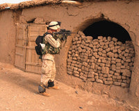 Poster print of a soldier conducting a raid at a bazaar in Afghanistan.
