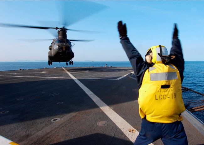 Boatswain's Mate signaling to a CH-47 Chinook helicopter poster print.