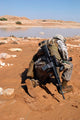 Soldier patrols along a riverbed on a search and rescue mission poster print.