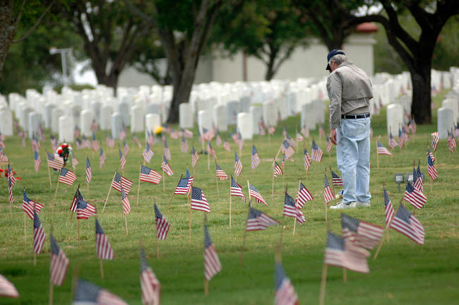A Family Member Pays Respects at a Grave Site Poster Print