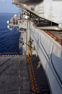Aboard USS Essex poster print featuring Marines and sailors fast-roping from a helicopter.