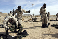 Marines and Sailors assisting each other in taking off MOPP suits after gas chamber exercise.