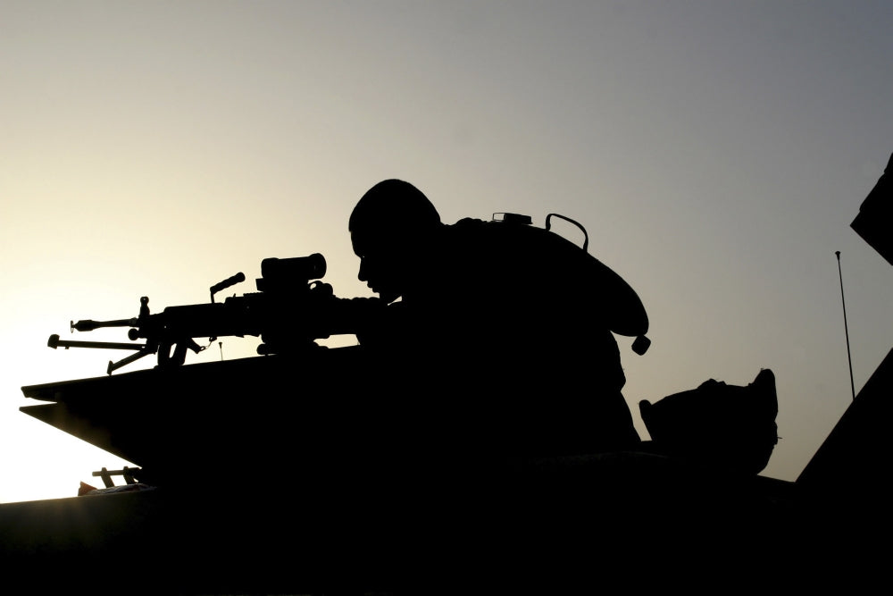 Squad Automatic Weapon (SAW) gunner looking through sights during convoy exercises poster print.