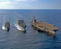 US Navy MH-60S Knighthawk helicopter conducting vertical replenishment drills poster print.