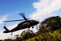 US Army UH-60 Black Hawk helicopter flying out of emergency landing zone poster print.