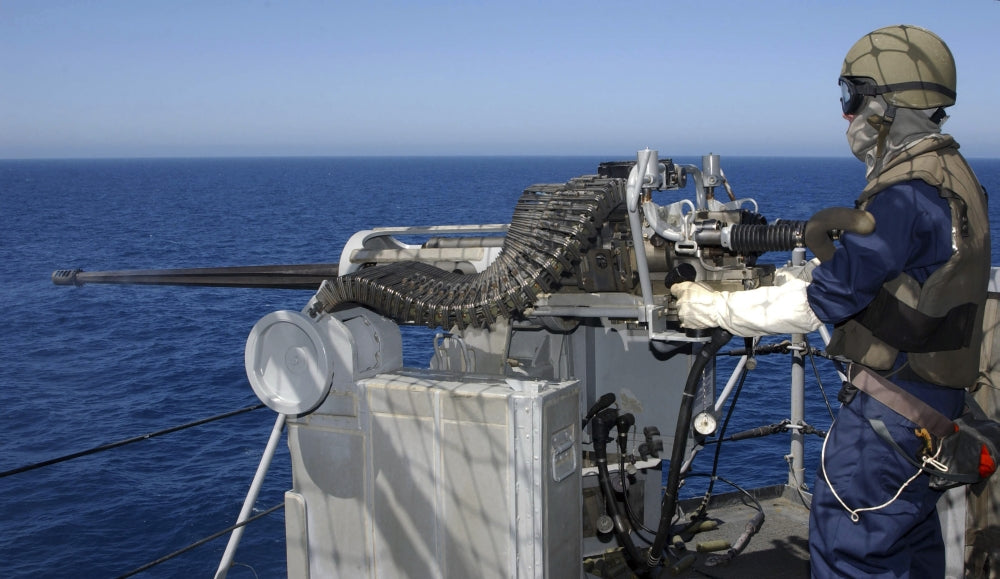U.S. Navy Gunner's Mate firing a .50-caliber machine gun during training aboard USS Boxer.