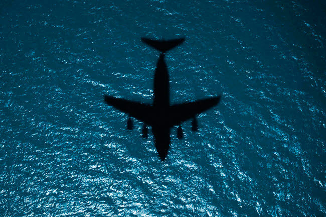 Silhouette of a military aircraft in flight over the Atlantic Ocean poster print