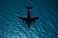 Silhouette of a military aircraft in flight over the Atlantic Ocean poster print