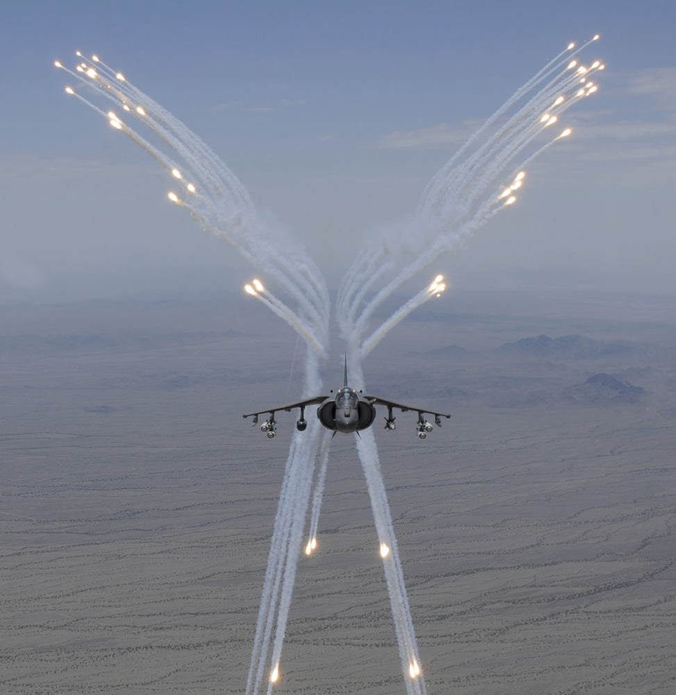 AV-8B Harrier firing flares during training flight poster print.
