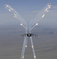 AV-8B Harrier firing flares during training flight poster print.