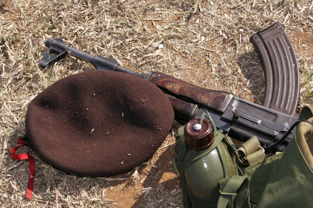 Poster print of a Mozambican soldier with rifle, military cover, and canteen.