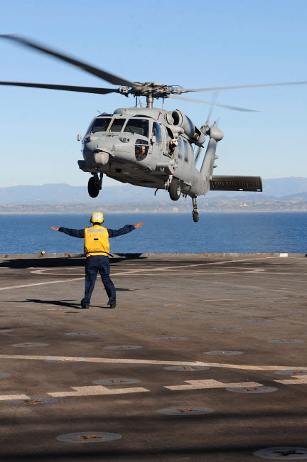 Boatswain’s Mate directing an MH-60S Sea Hawk helicopter on USS Comstock poster print.