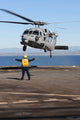 Boatswain’s Mate directing an MH-60S Sea Hawk helicopter on USS Comstock poster print.