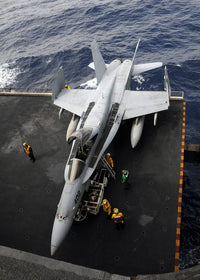 Sailors moving an F/A-18C Hornet into the hangar bay poster print