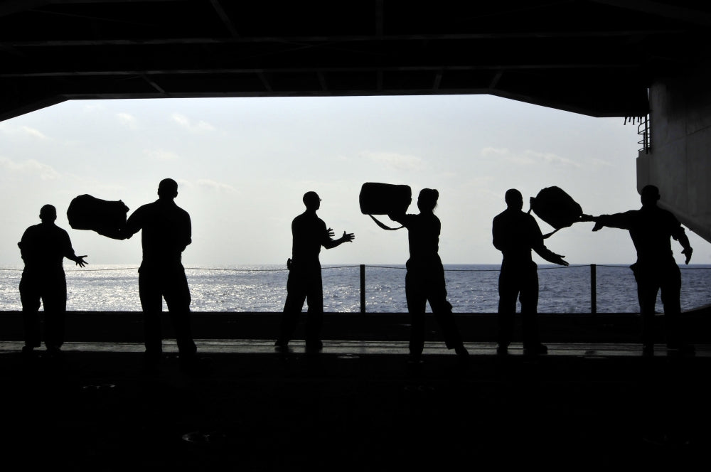 Pacific Ocean Sailors Poster Print showing sailors on USS Ronald Reagan passing kits.