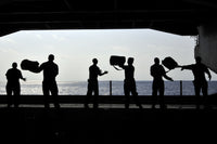 Pacific Ocean Sailors Poster Print showing sailors on USS Ronald Reagan passing kits.