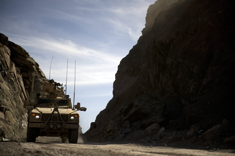 MRAP vehicle driving through the mountains of Afghanistan poster print.