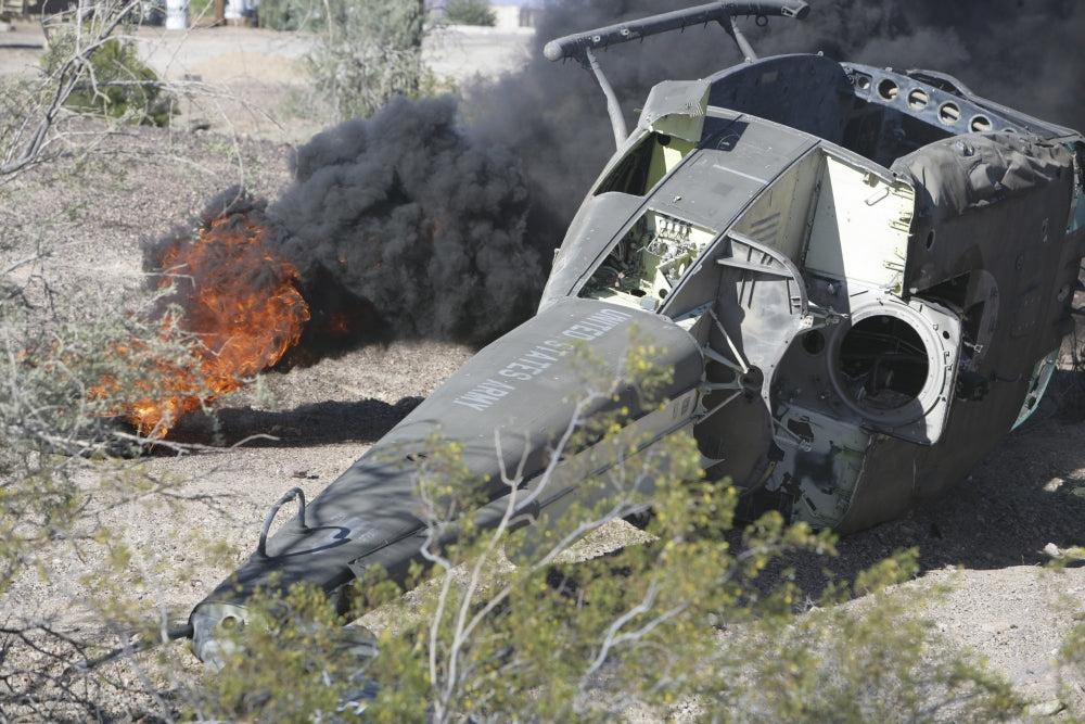 Black smoke rising from the wreckage of a downed UH-1N Huey poster print.