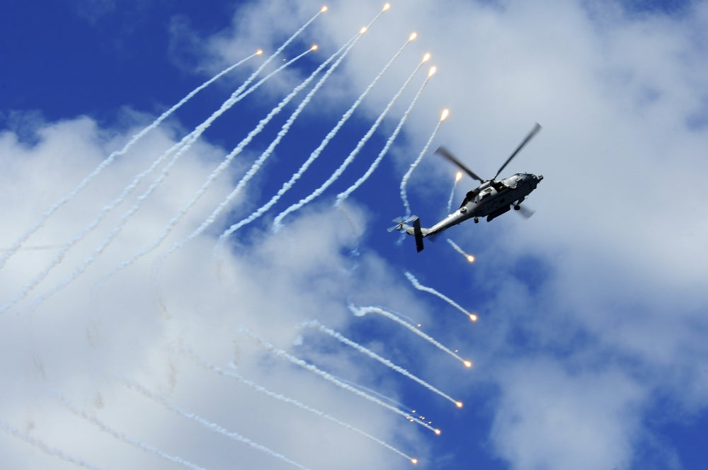 HH-60H Sea Hawk helicopter releasing countermeasure flares poster print.