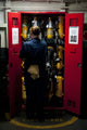 Fireman stowing a self-contained breathing apparatus in a locker poster print.