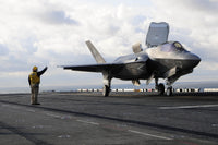 Aviation Boatswain's Mate signaling F-35B Lightning II off flight deck poster print.
