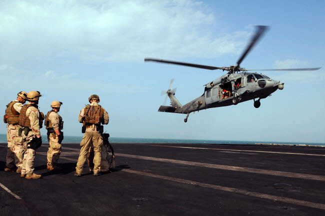 Sailors preparing to board an MH-60S Sea Hawk helicopter poster print.