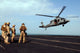 Sailors preparing to board an MH-60S Sea Hawk helicopter poster print.