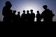 Poster print of U.S. Marines and civilian contractors gathering for a briefing.