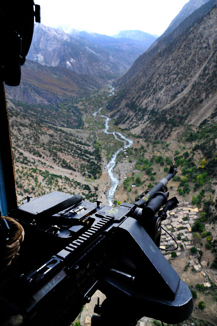Aerial gunner surveying Afghanistan during a combat mission poster print.