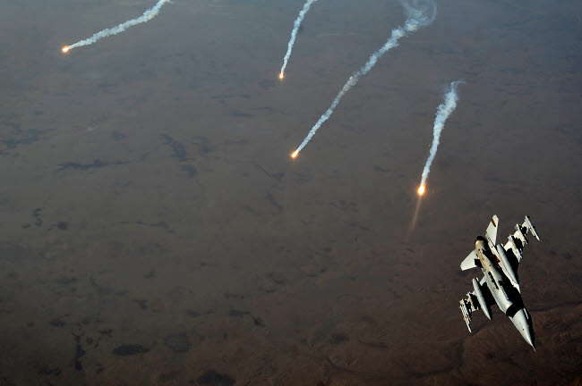 F-16 Fighting Falcon jet poster print releasing flares over Iraq.