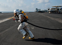 Aviation Boatswain’s Mate carrying a fire hose during a fire drill poster print.