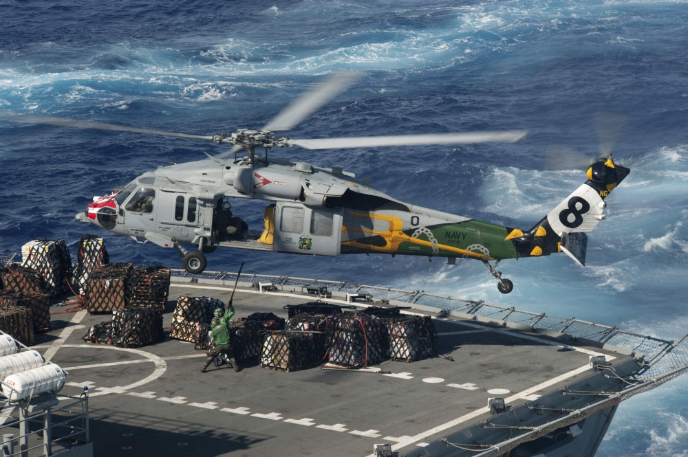 MH-60S Sea Hawk helicopter picking up supplies from USNS Bridge over the Pacific Ocean.