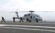 Sailors leaving landing area of an HH-60H Sea Hawk helicopter poster print.