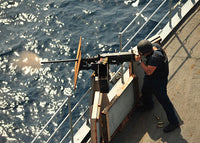 Seaman firing a 50-caliber machine gun aboard USS Gunston Hall poster print