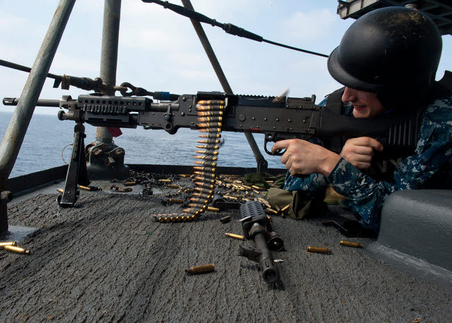 A Sailor fires an M-240B machine gun aboard USS Enterprise.