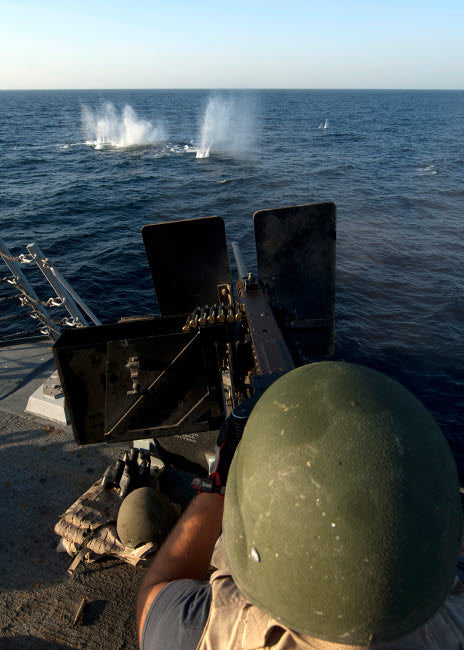Sailor firing 50-caliber machine gun aboard USS James E. Williams poster print