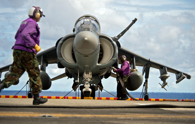 Aviation boatswain's mates refueling an AV-8B Harrier jet poster print.