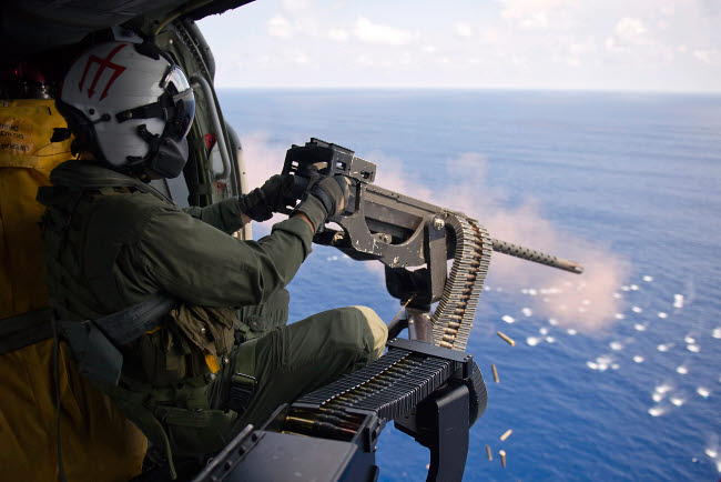 Naval Aircrewman firing a 50-caliber machine gun from MH-60S Knighthawk poster print.