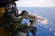 Naval Aircrewman firing a 50-caliber machine gun from MH-60S Knighthawk poster print.