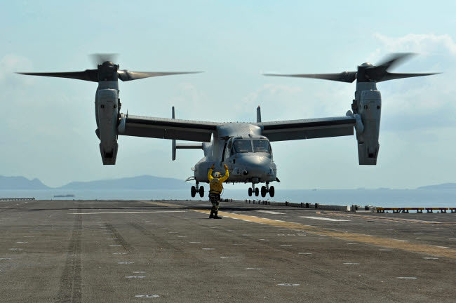 Aviation Boatswain's Mate signals an MV-22 Osprey during takeoff poster print