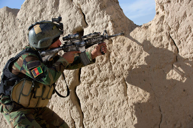 Afghan Commando keeps watch for insurgents during a security operation poster print.