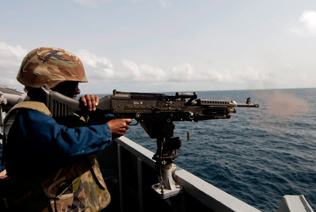 Sailor firing M240B machine gun aboard USS Winston S. Churchill poster print